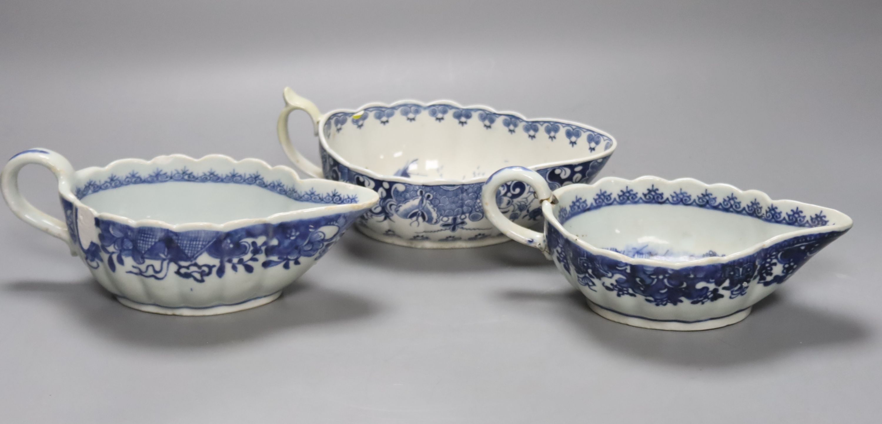 A Worcester Doughnut pattern blue and white sauceboat circa 1775 and two Chinese blue and white sauceboats, Qianlong period, longest 21cm